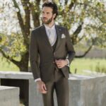 Homme élégant en costume trois pièces marron avec cravate