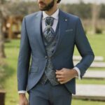Homme élégant en costume trois pièces bleu avec gilet fleuri
