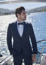 Homme élégant en smoking bleu marine sur un yacht