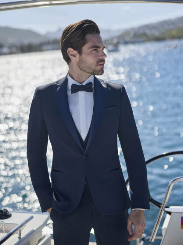 Homme élégant en smoking bleu marine sur un yacht