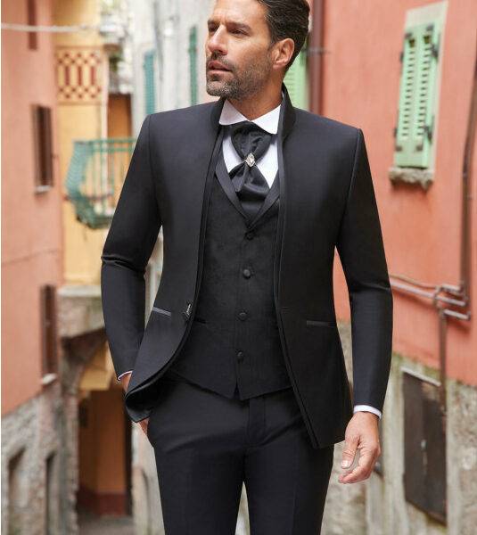 Homme élégant en costume trois pièces noir avec cravate