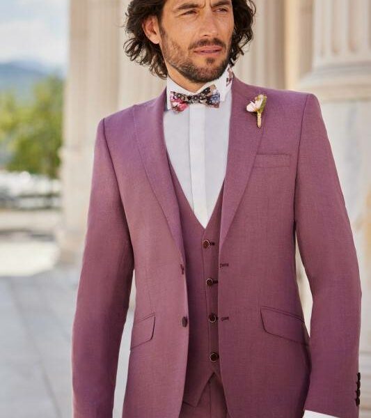 Homme en costume trois pièces rose mauve avec nœud papillon
