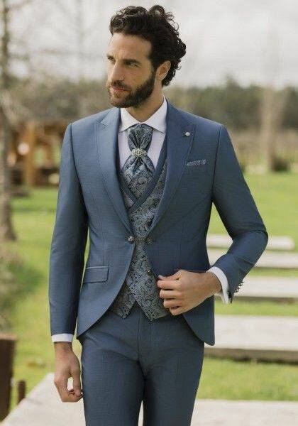 Homme élégant en costume trois pièces bleu avec gilet fleuri
