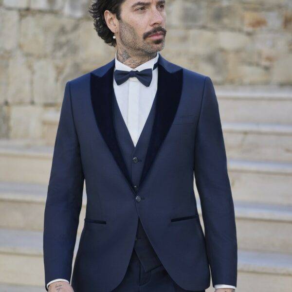 Homme élégant en smoking bleu marine avec nœud papillon