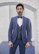 Homme élégant en costume trois pièces bleu avec nœud papillon