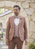 Homme élégant en costume trois pièces rose poudré avec nœud papillon