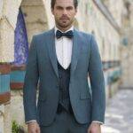 Homme en costume trois pièces bleu avec nœud papillon