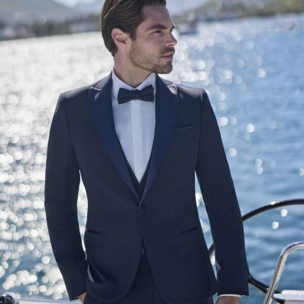 Homme élégant en smoking bleu marine sur un yacht